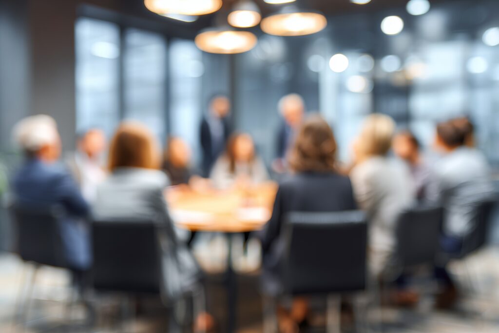 Professional business team members sitting together around a wooden table during a corporate office meeting session