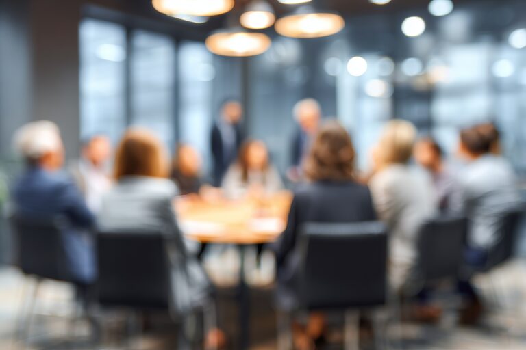 Professional business team members sitting together around a wooden table during a corporate office meeting session