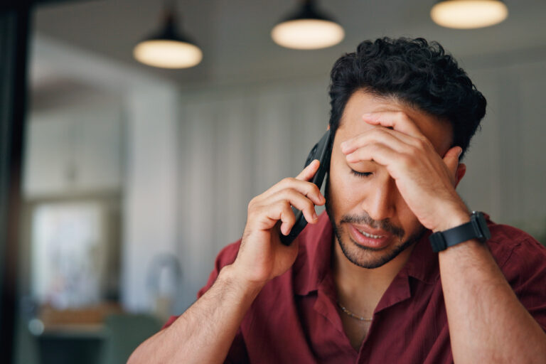 Upset, man and talk in home with phone call, feedback and disappointed for financial crisis problem. Frustrated, person and conversation in house with tech, contact and stress for finance debt risk