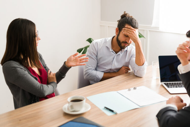 Upset young woman arguing with his ex husband about the divorce settlement with a lawyer